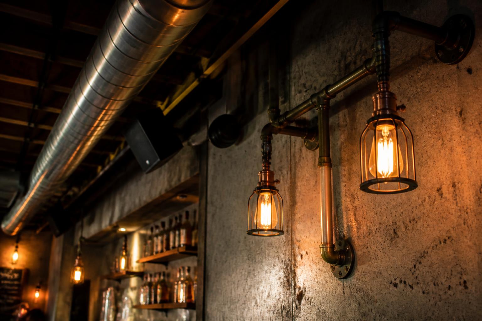 Détails industriels : tuyaux cuivre et ampoules Edison